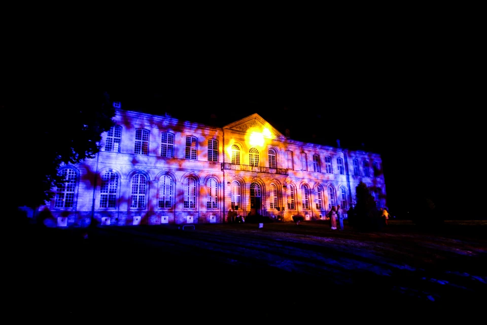 Façade baroque d'un château ou hôtel particulier illuminée la nuit par un mapping vidéo
