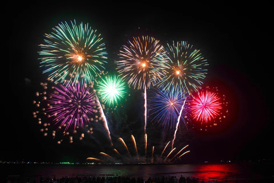 Feu d'artifice nocturne illuminant le ciel au-dessus d'un manoir géorgien en brique rouge, éclairé à l'orange